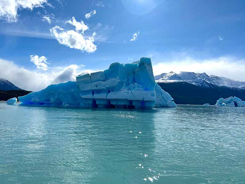 Barco para em frente a iceberg durante passeio por todos os glaciares