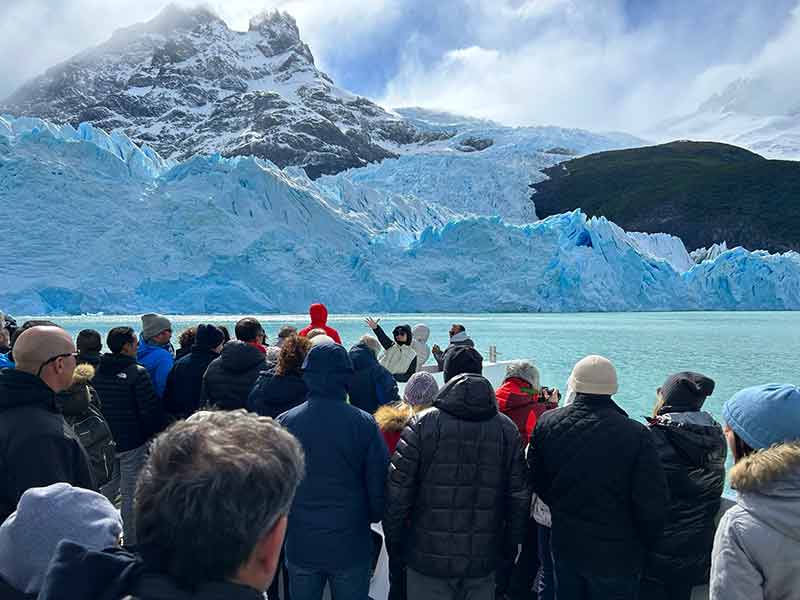 Pessoas se aglomeram em parte externa de barco para ver o Glaciar Spegazzini