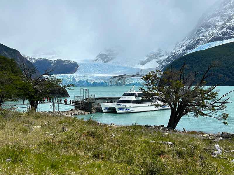 Barco parado em frente ao Glaciar Spegazzini, em El Calafate, em dia nublado e com neblina