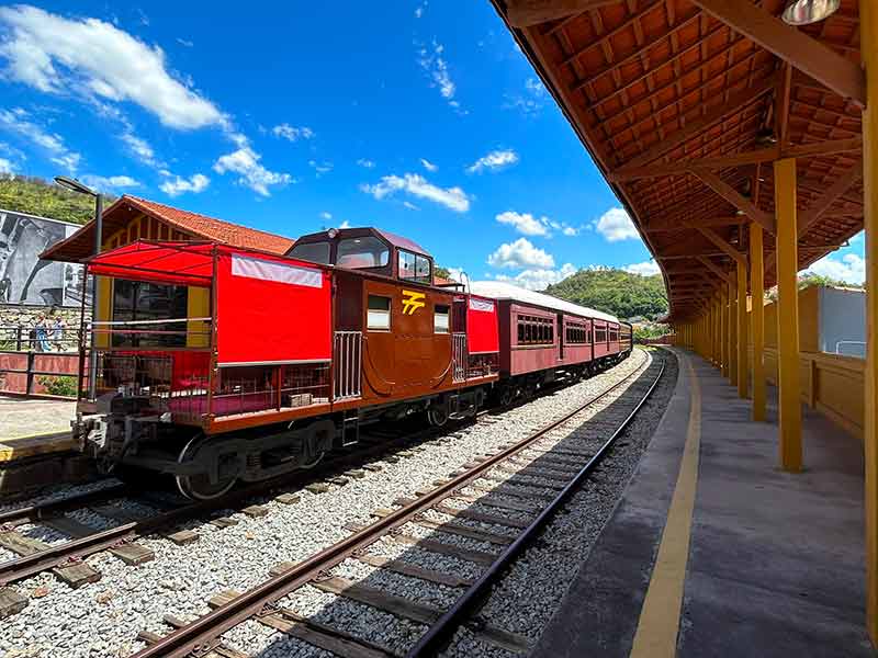 Trem parado na estação de Guararema em dia de céu azul