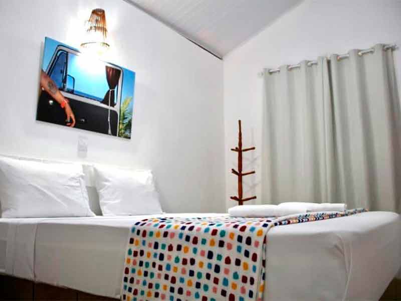 Quarto da Pousada Du Forte com cama de casal, paredes brancas e quadro