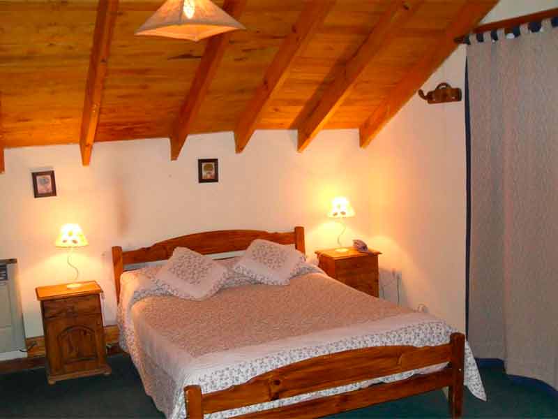 Quarto do Solares del Sur com cama de casal, abajur e móveis de madeira