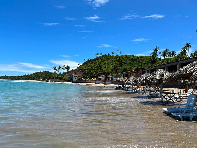 Mar vazio na praia de Barreira do Boquerão, dica de o que fazer em Japaratinga, com espreguiçadeiras na areia