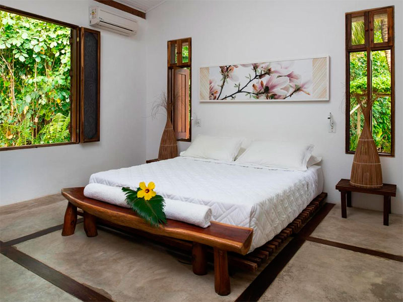 Cama de casal em quarto claro com ar-condicionado da pousada Amendoeira, em São Miguel dos Milagres