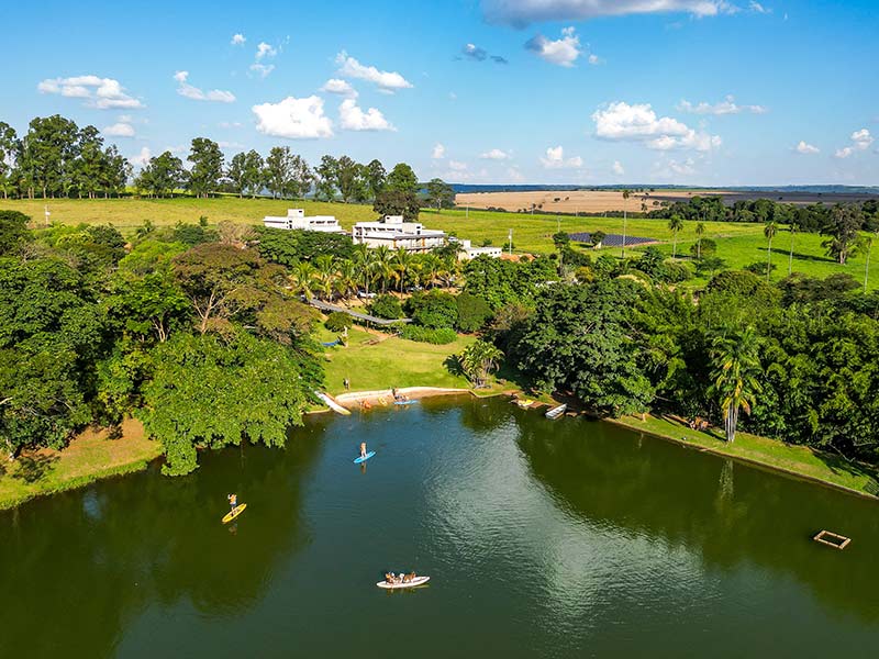 Pessoas andam de caiaque e fazem stand up paddle no lago do hotel faenda Areia que Canta