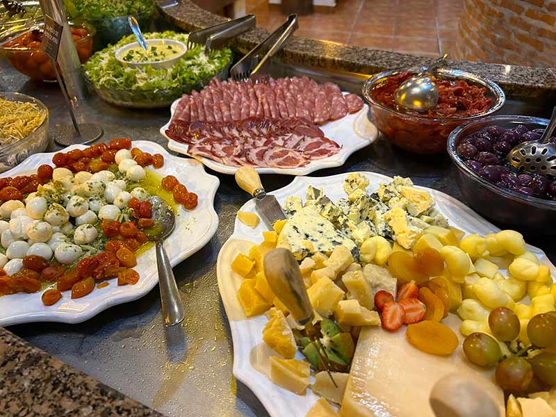 Queijos, frios e saladas no jantar do hotel fazenda Areia que Canta, em Brotas