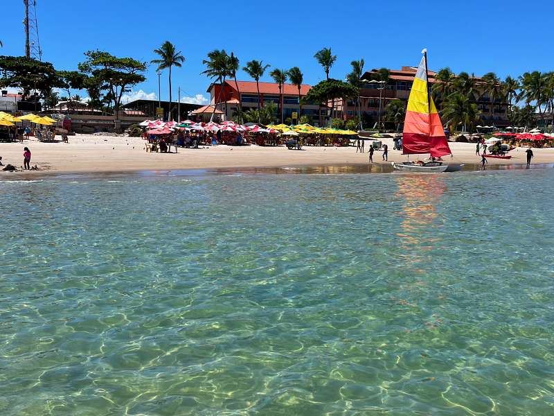 Mar cristalino com jangada ao fundo na Praia do Francês, em Marechal Deodoro, Alagoas