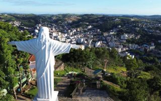 Cristo Redentor, visto de cima, de braços abertos para Serra Negra