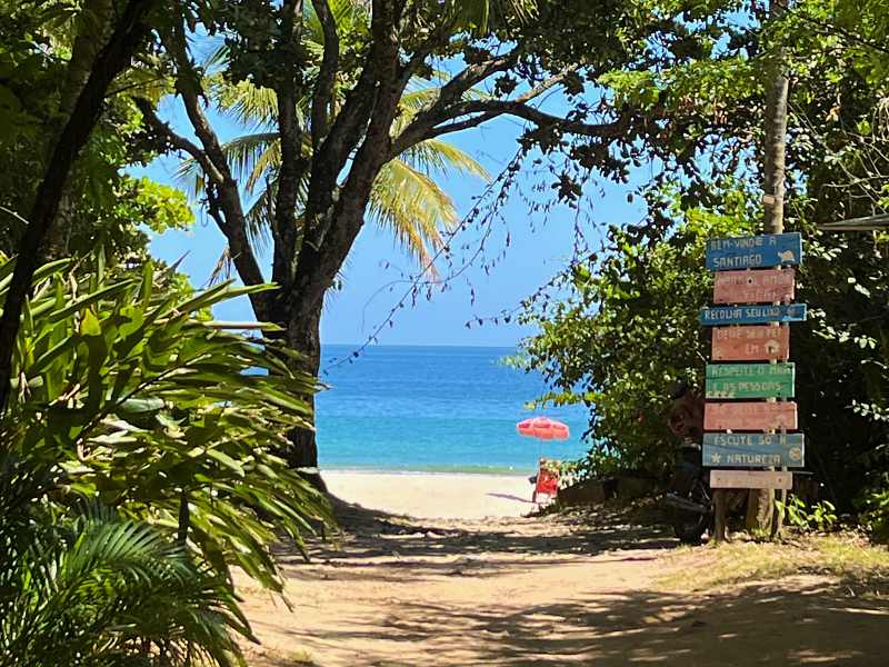 Rua de terra com mar ao fundo de acesso à praia (Foto: Esse Mundo É Nosso)