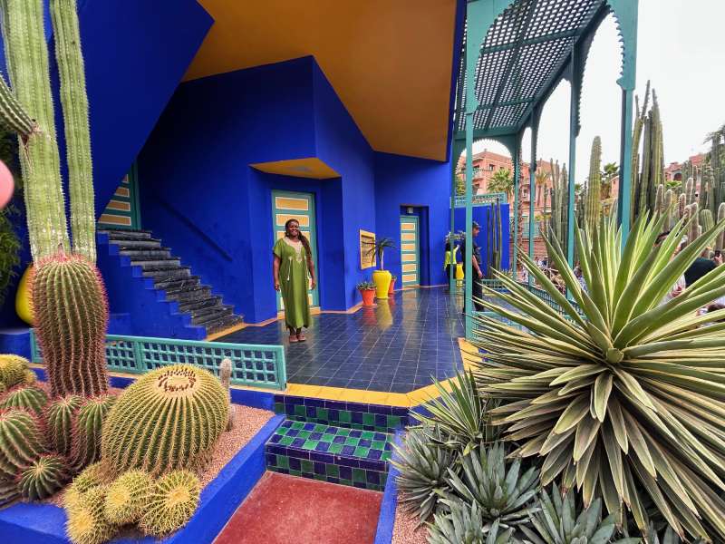 Turista posa em uma das casas azuis do Jardim Majorelle, dica de o que fazer em Marrakech