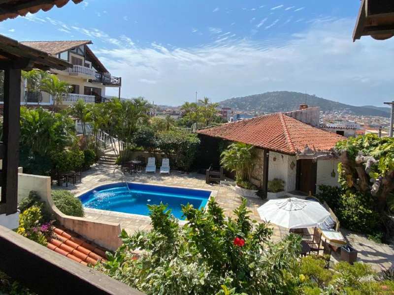 Área externa da pousada Caminho do Sol com piscina vazia em dia de céu azul com nuvens