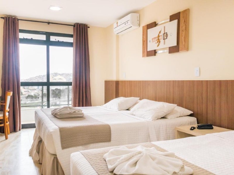 Quarto do Mediterrane Hotel, dica de onde ficar em Arraial do Cabo, com duas camas, cabeceira de madeira e varanda