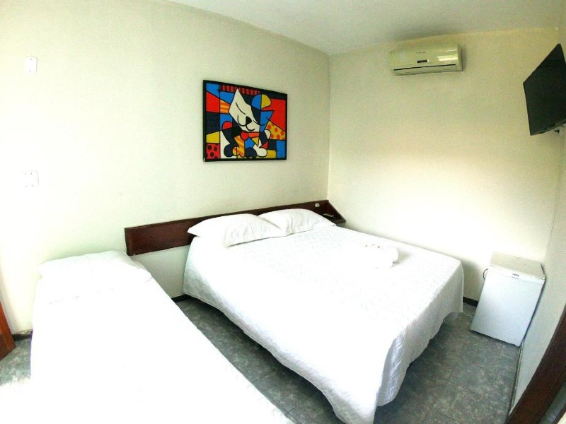 Quarto do Paraíso do Atlântico com camas de casal e de solteiro e quadro na parede