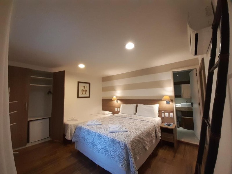 Quarto da Pousada da Prainha, dica de onde ficar em Arraial do Cabo, com cama de casal e frigobar