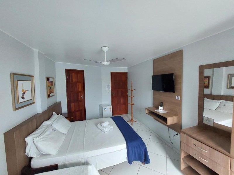 Quarto da Pousada Fernandes com cama de casal, TV e ventilador de teto