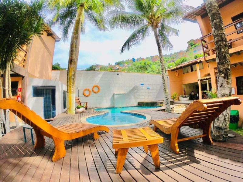 Área externa da Pousada Solar da Praia com piscina e espreguiçadeiras vazias