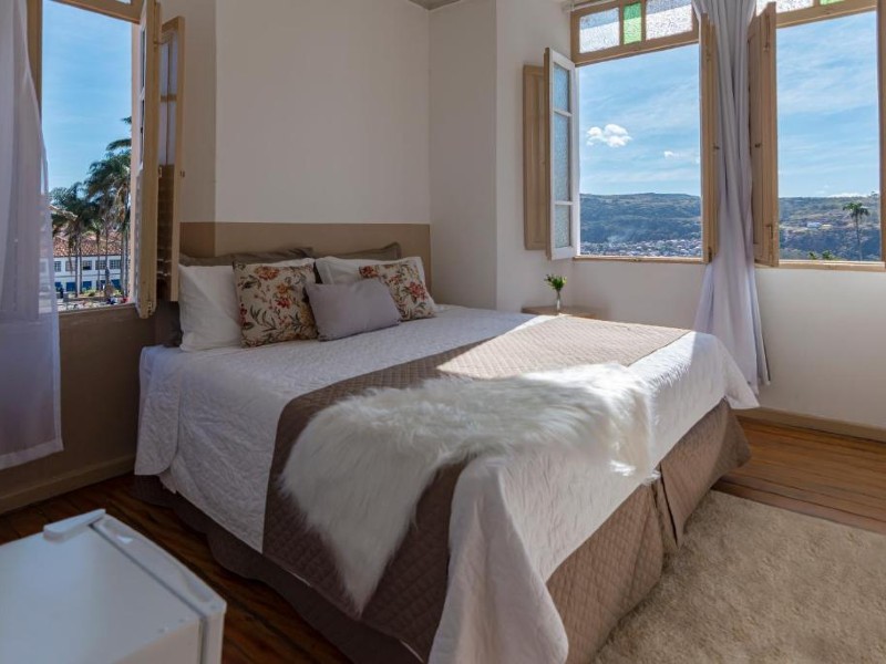 Quarto da Canto do Chafariz com cama de casal e janelas com vista para a montanha