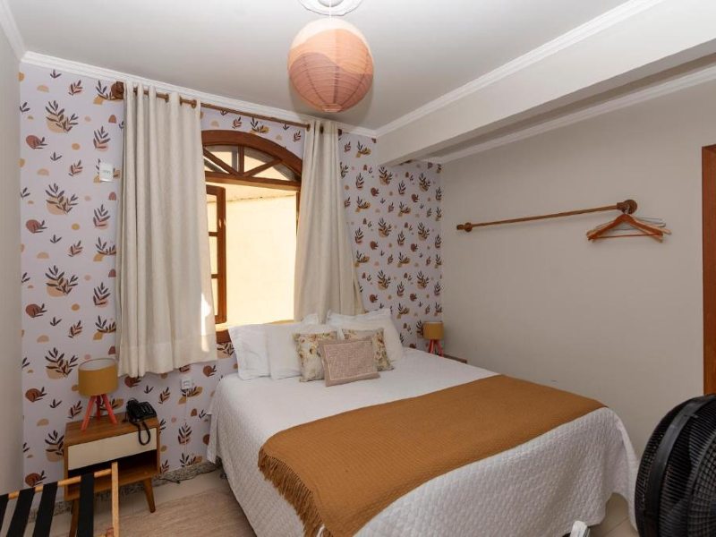 Quarto da Pousada Capim Limão, dica de onde ficar em Diamantina, com papel de parede e cama de casal