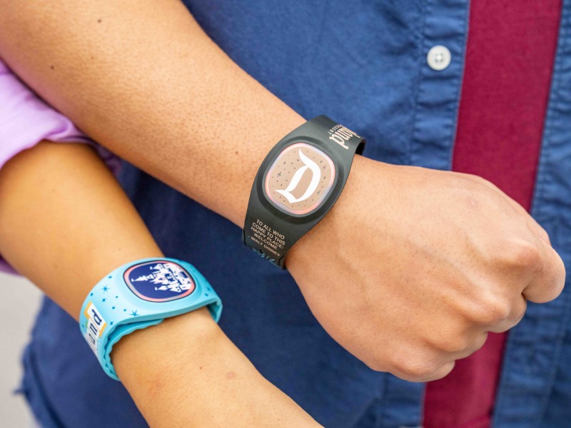 Pessoas mostram suas magic bands para usar a Lightning Lane na Disney