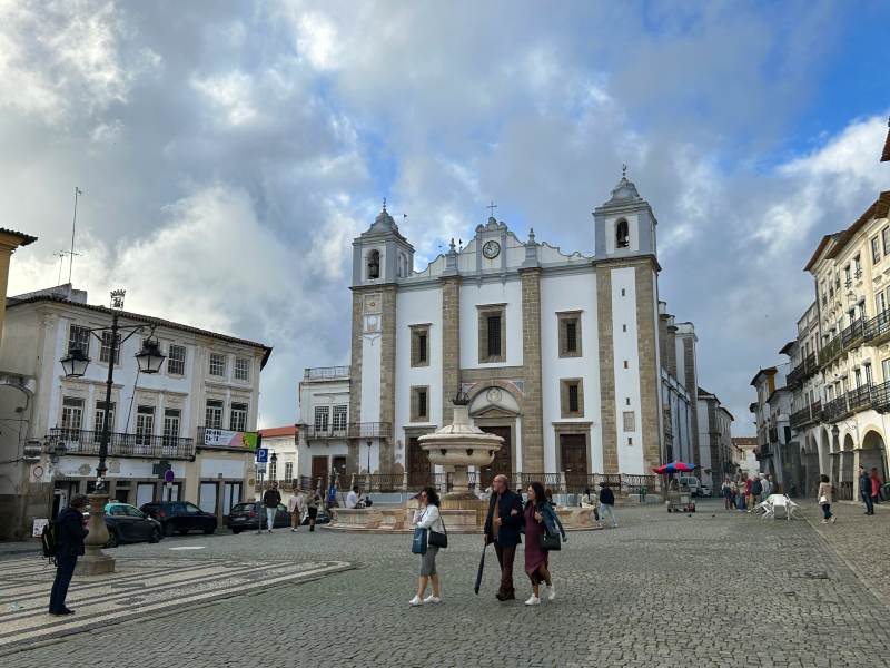 Pessoas na Praça do Giraldo, em Évora, em frente à igreja