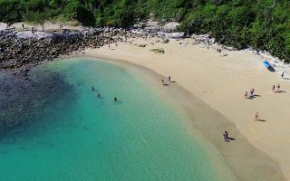 Vista área das águas cristalinas e dos rochedos da Praia das Conchas em Cabo Frio