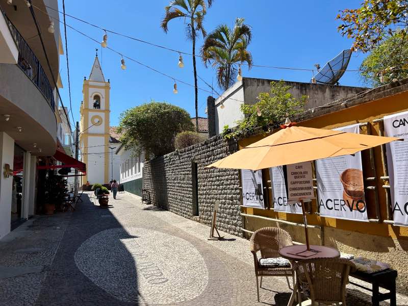 Viela no centrinho de Cunha co,m igreja à frente em dia de céu azul