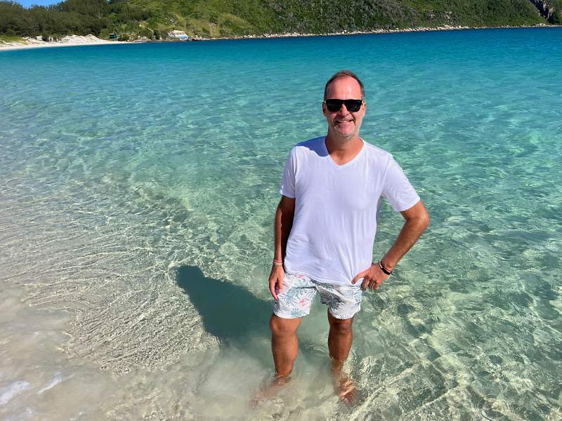 Homem posa pra foto nas águas cristalinas da Ilha do Farol em Arraial do Cabo