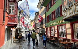 Augustinergasse, dica de o que fazer em Zurique, com bandeiras da Suíça e construções históricas coloridas