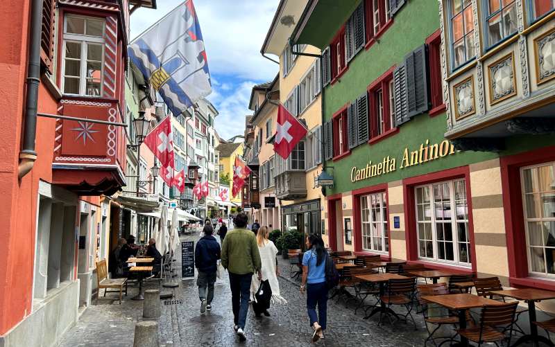Augustinergasse, dica de o que fazer em Zurique, com bandeiras da Suíça e construções históricas coloridas