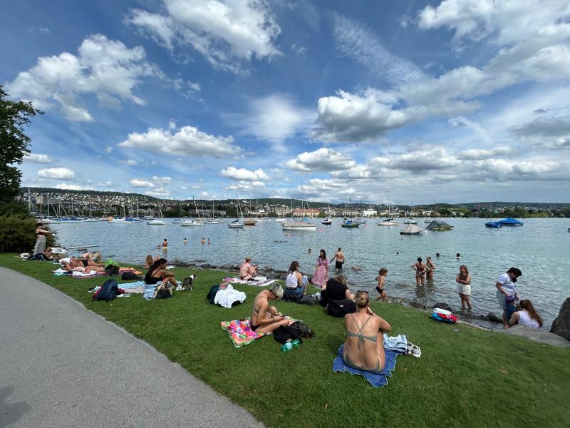 Suíços aproveitam o verão em praia de lago