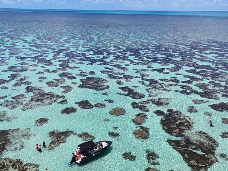 Lancha em meio aos Parrachos do Rio do Fogo com água cristalina e céu azul