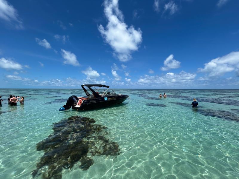Lancha parada nas piscinas naturais no Rio Grande do Norte em dia de céu azul