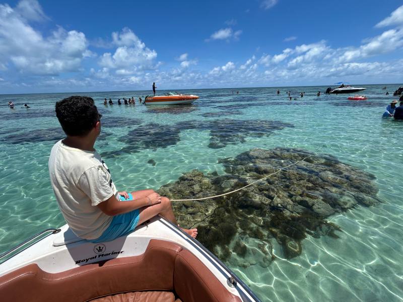 Homem sentado em lancha nas piscinas naturais no Rio Grande do Norte