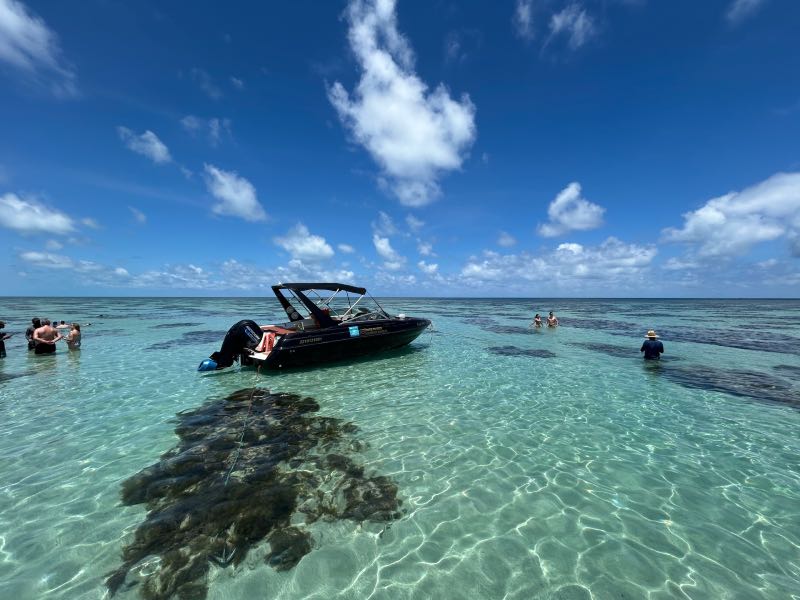 Pessoas aproveitam as águas claras dos Parrachos do Rio do Fogo, um dos passeios em Natal, em dia de céu azul