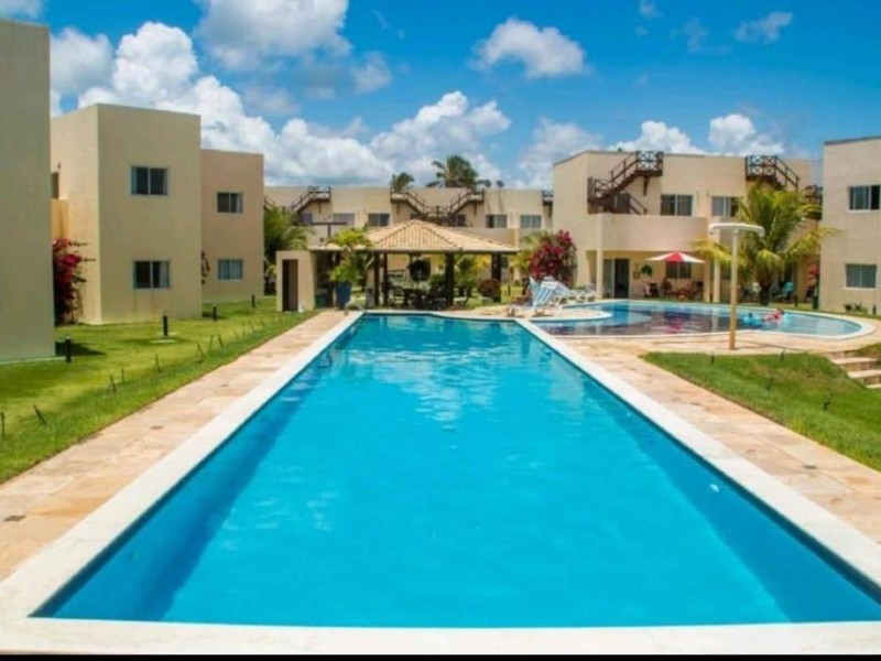 Área externa com piscina da Chalet Paraíso em dia de céu azul com poucas nuvens