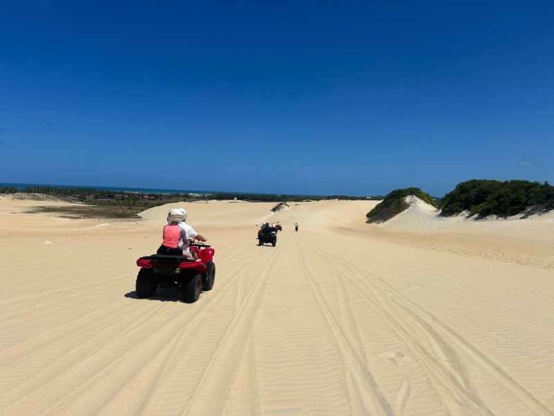 Pessoas andam de quadriciclo em dunas no Rio Grande do Norte.