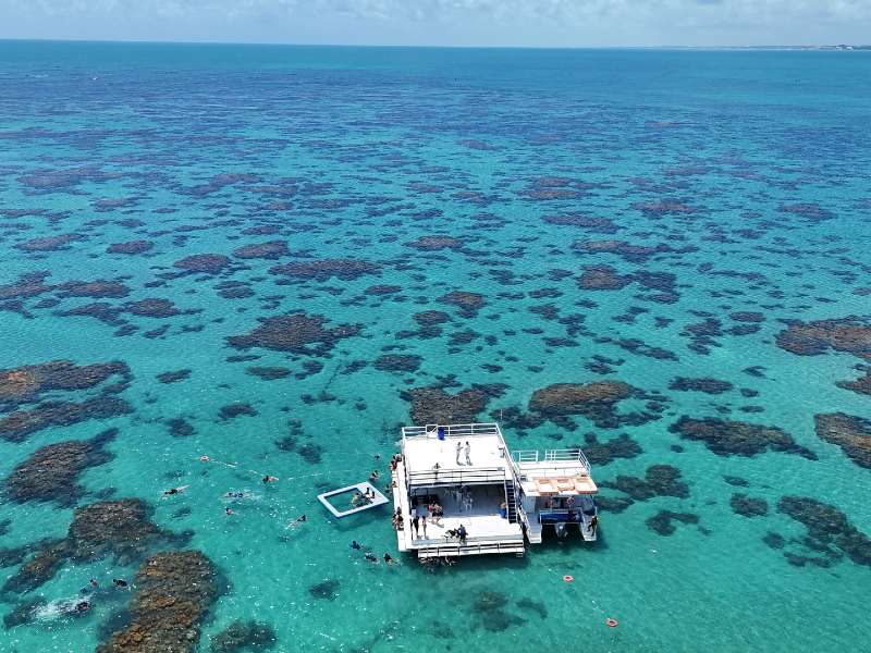 Barco parado nos Parrachos de Maracajaú com águas cristalinas e visto de cima