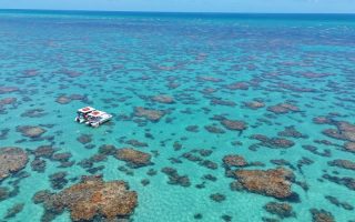 Parrachos de Maracajaú vistos de cima com água verde cristalina e barco no mar