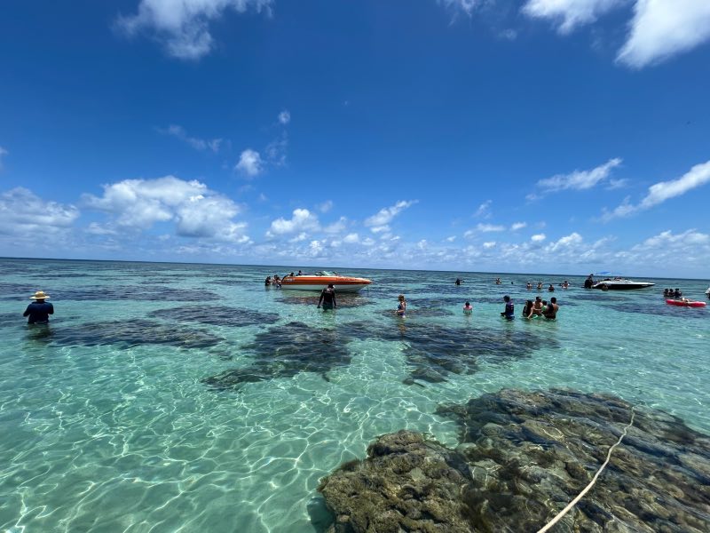 Pessoas e lanchas aproveitam as piscinas naturais do Rio do Fogo  em dia de céu azul