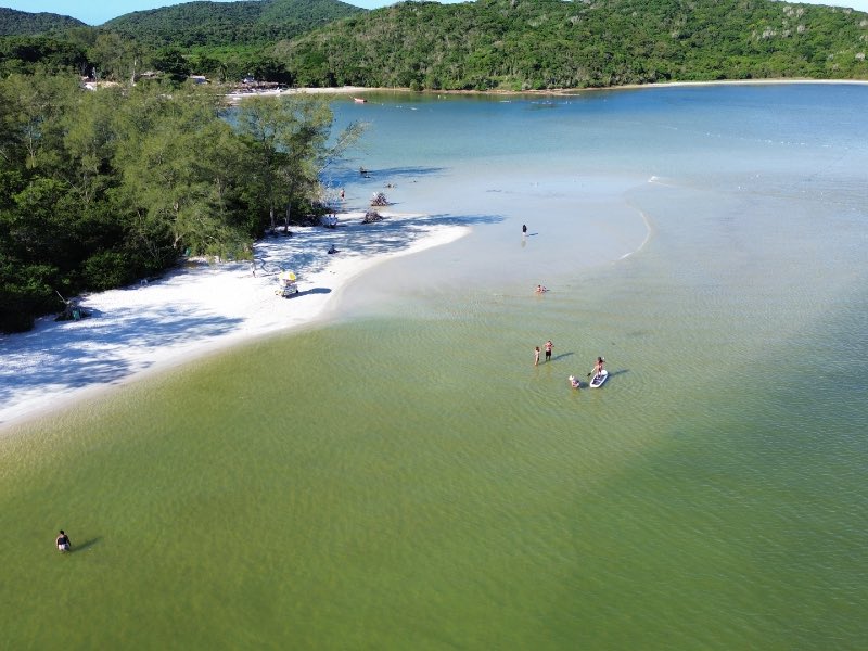 Pessoas aproveitam a água esverdeada da Ilha do Japonês, dica de o que fazer em Cabo Frio