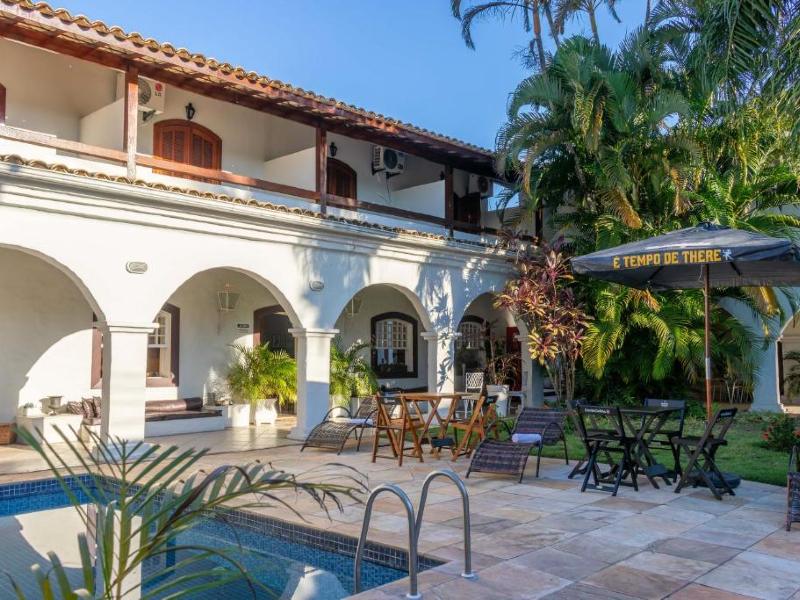 Área da piscina da Pousada Boulevard com mesas vazias em dia de céu azul