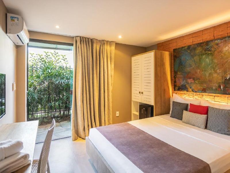 Quarto da Bravo Pousada Design com cama de casal, TV, ar-condicionado e varanda térrea