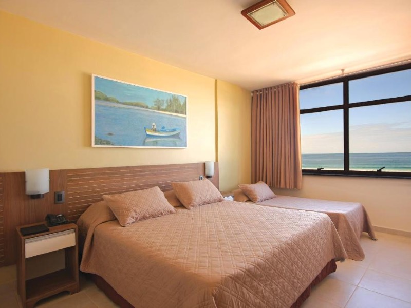 Quarto do Hotel Malibu com cama de casal e de solteiro e vista para o mar