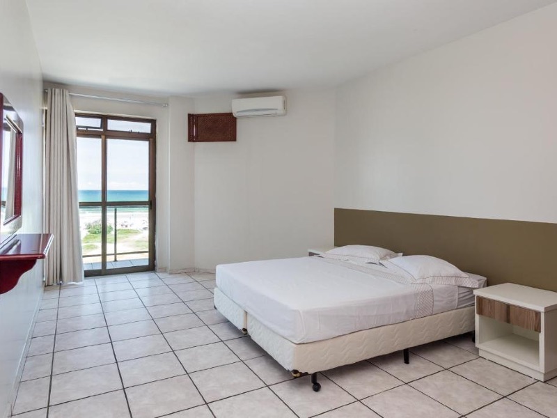 Quarto simples do Porto Príncipe com cama de casal, varanda e TV