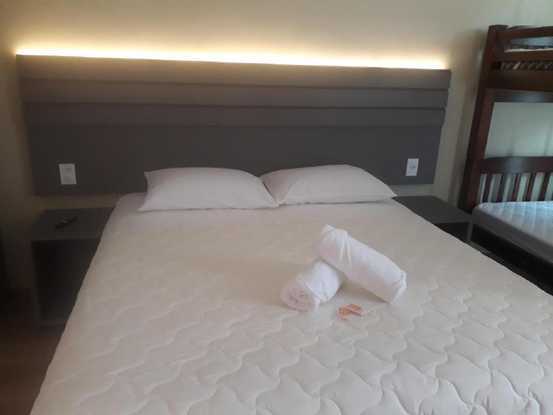 Quarto do Velas do Forte, dica de hotel em Cabo Frio, com cama de casal e luz atrás da cabeceira