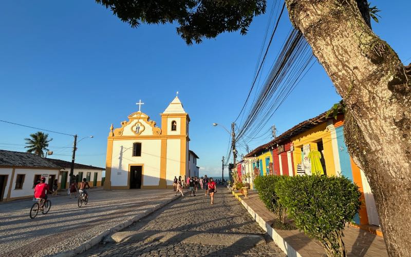Igreja Matriz de Nossa senhora D'Ajuda com casinhas coloridas em Arraial d'Ajuda