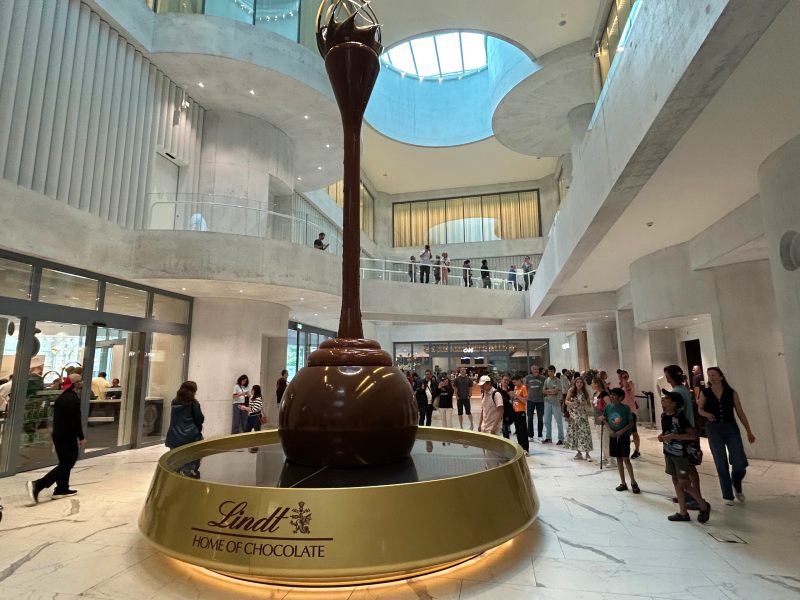Pessoas ao redor da maior fonte de chocolate do mundo na Suíça