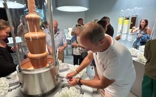 Homem pega chocolate ao leite da fonte no Museu da Lindt, em Zurique