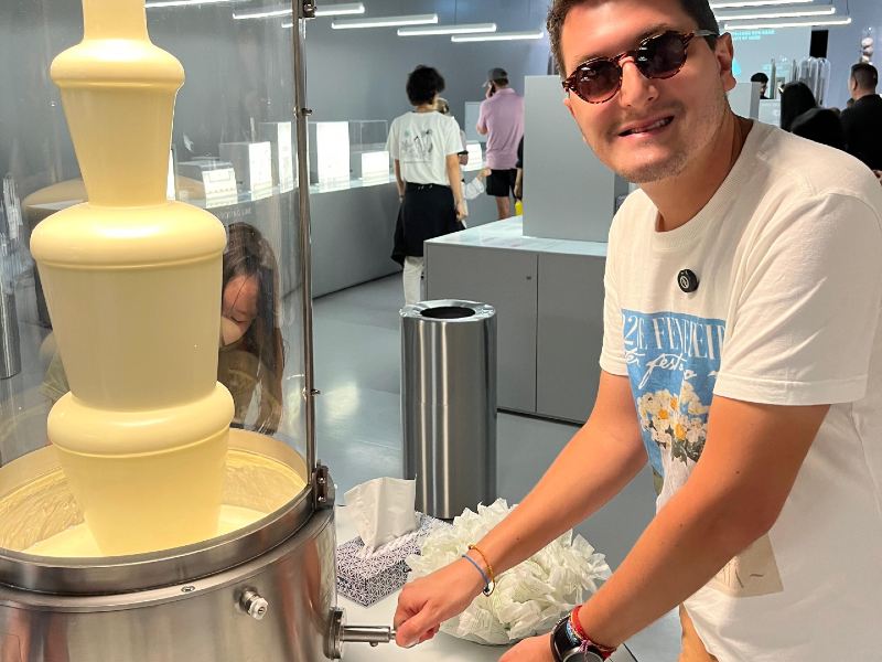 Homem pega chocolate branco direto da fonte no Museu da Lindt, em Zurique