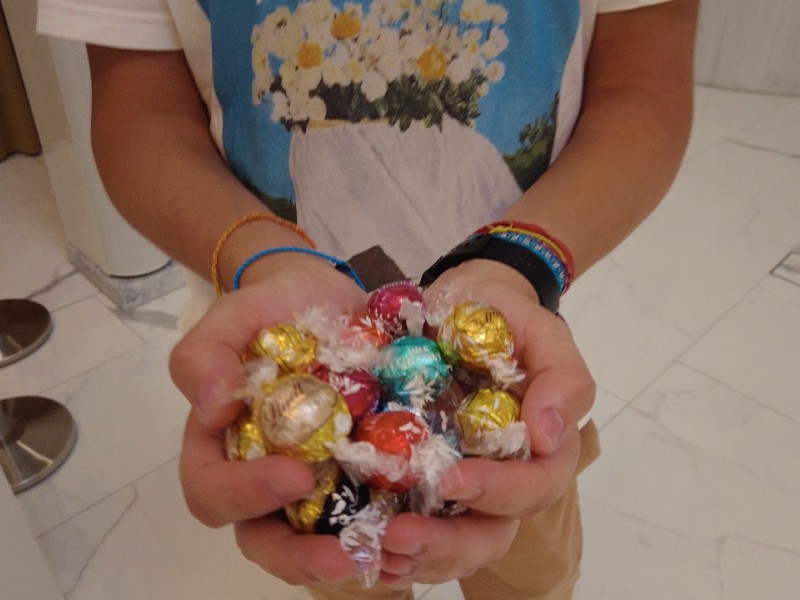 Homem segura um monte de Lindoor na mão na Suíça